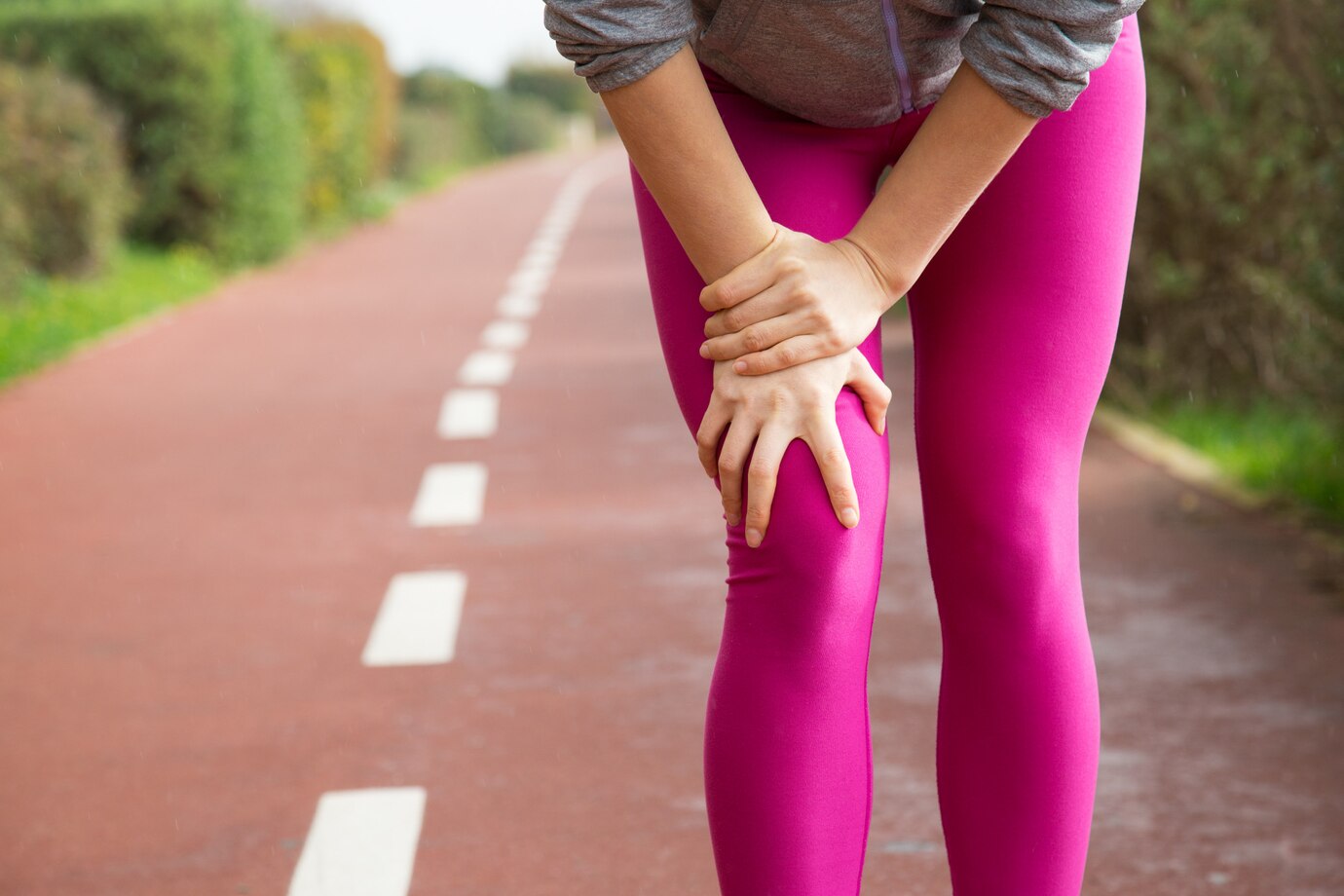 female-jogger-wearing-pink-tights-injuring-knee_1262-18227